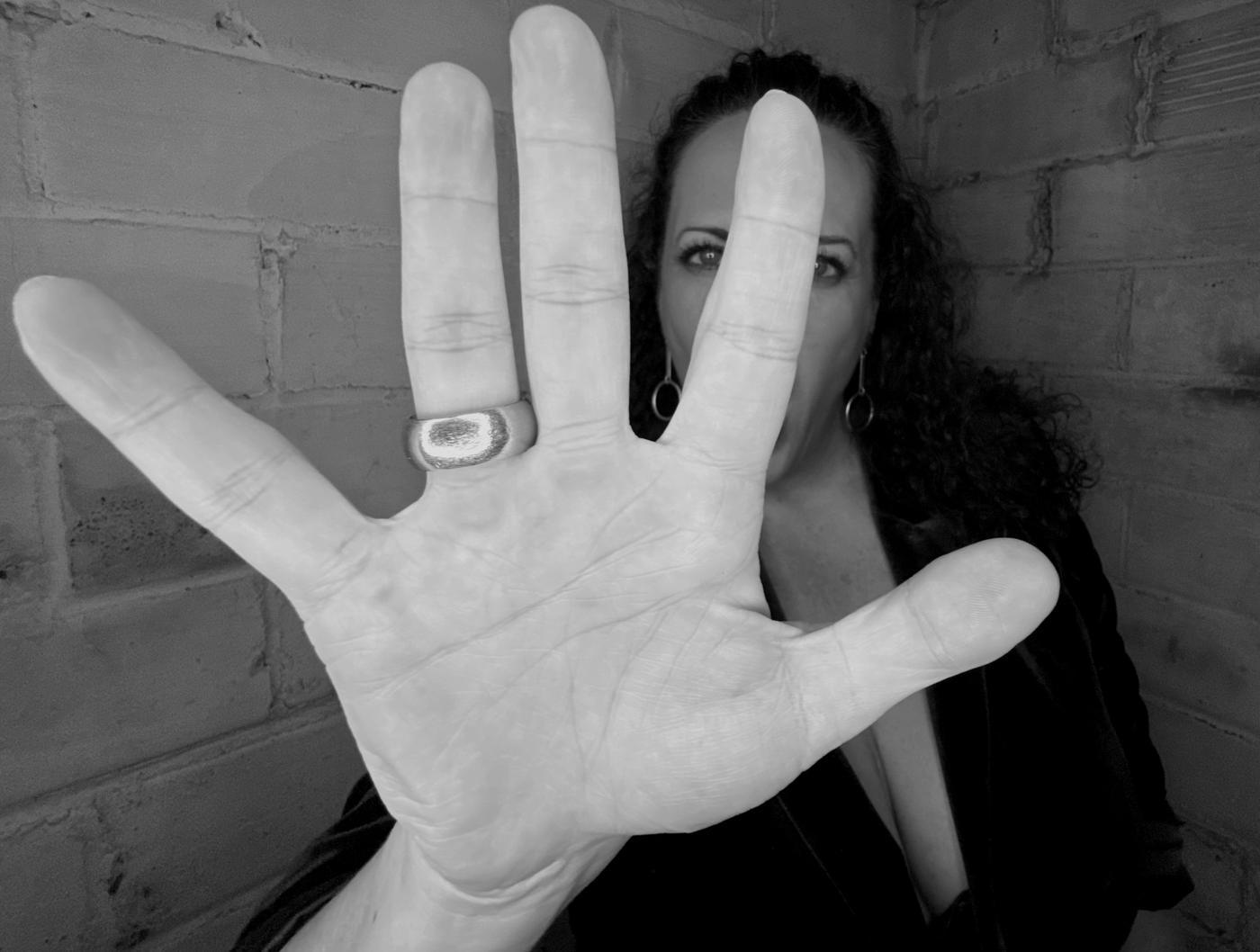 Tiff Webber, founder of Wellness Shitshow, holding her hand up to the camera